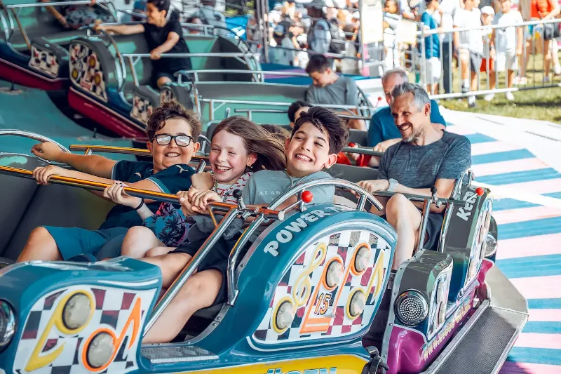 Famille souriante dans un manège lors d'une fête populaire